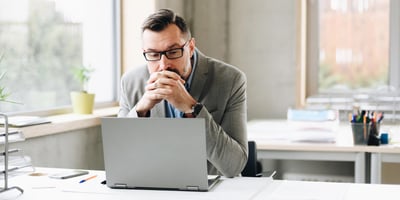 Business owner comparing HubSpot free CRM limitations against paid plans